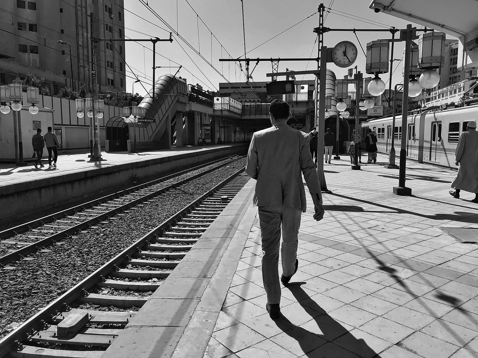Commuters waiting on a Cairo Metro platform as a train pulls into the station